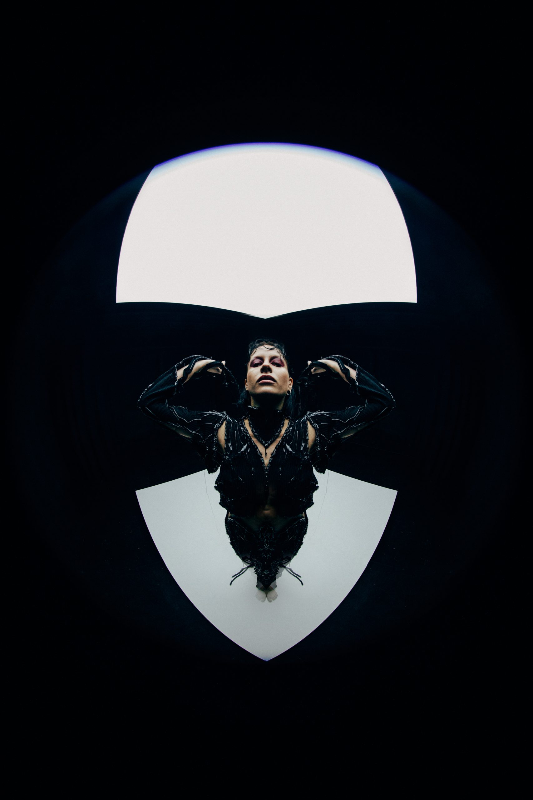 full body fisheye image of mdoel wearing skin tight black cutout dress looking upward