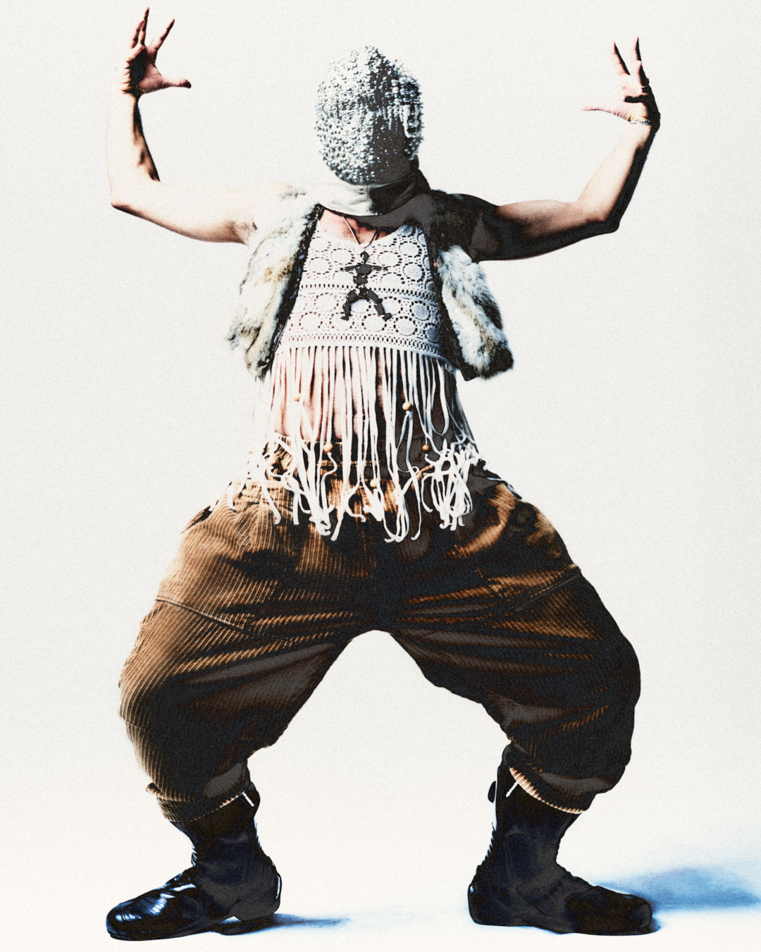 male model facing the camera with hands high and legs wide dressed in mask fur and corduroy pants