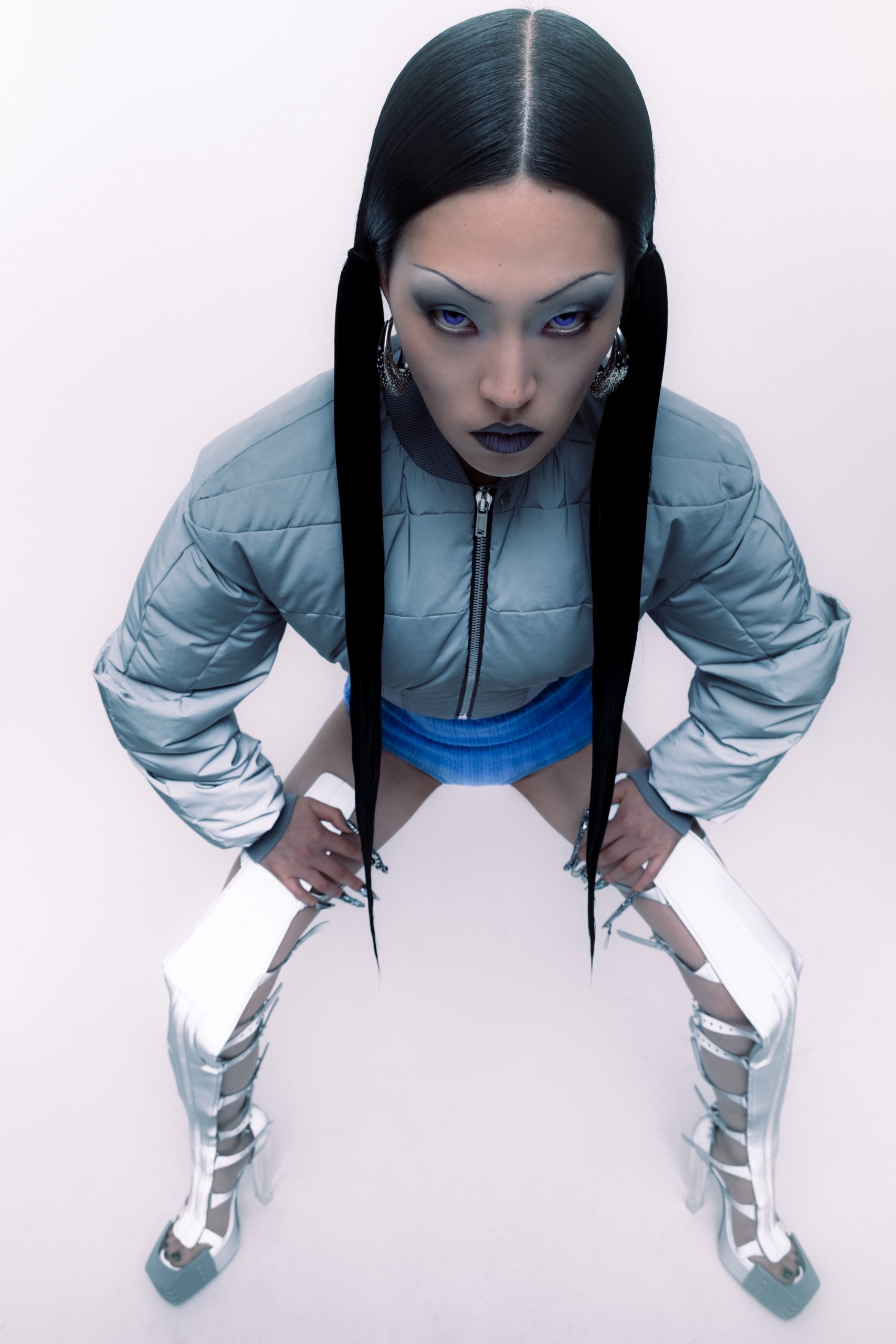 Closeup shot of asian model looking into the camera with sleek-to-the-side hair dressed in all grey rick owens