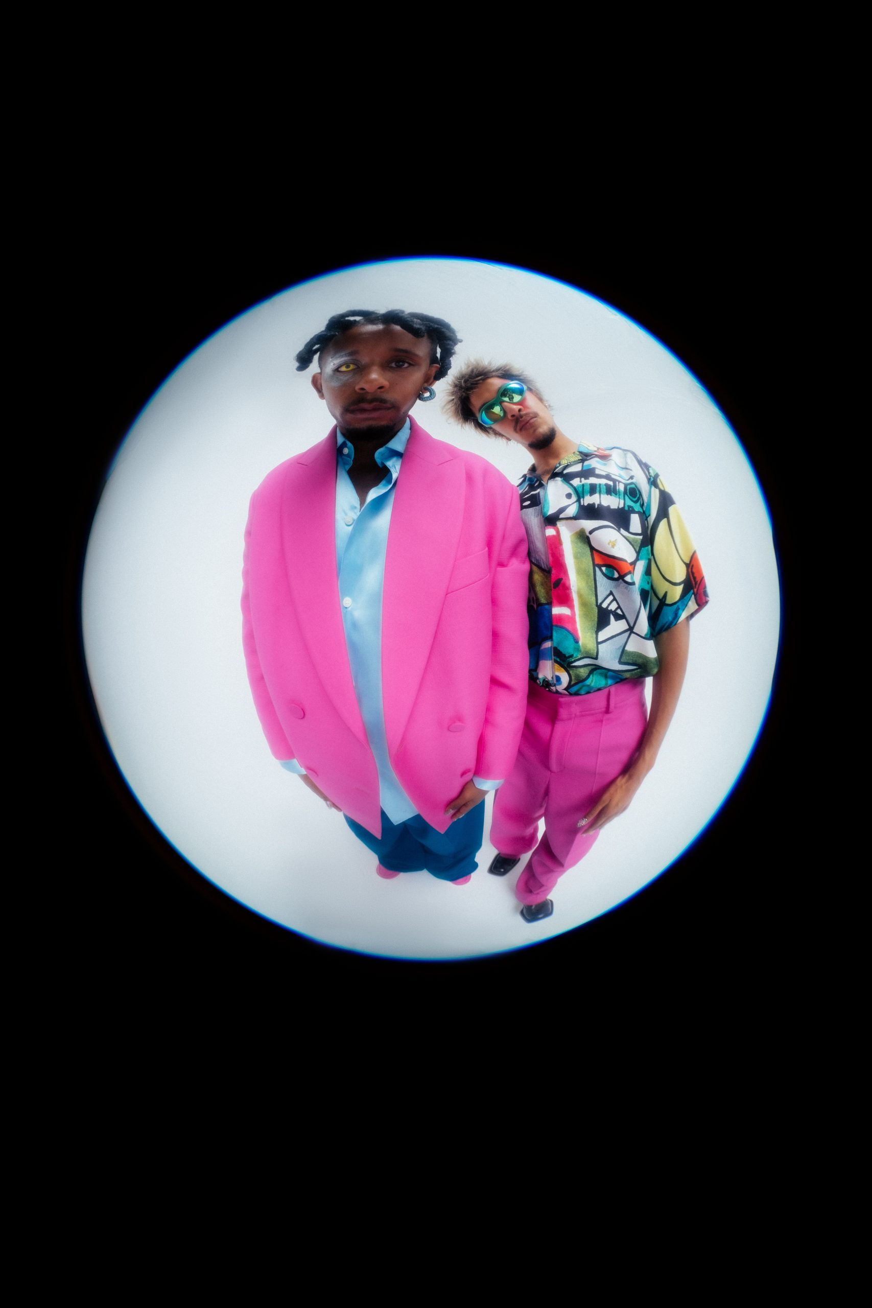 Fisheye closeup shot of two male models in editorial colorful looks