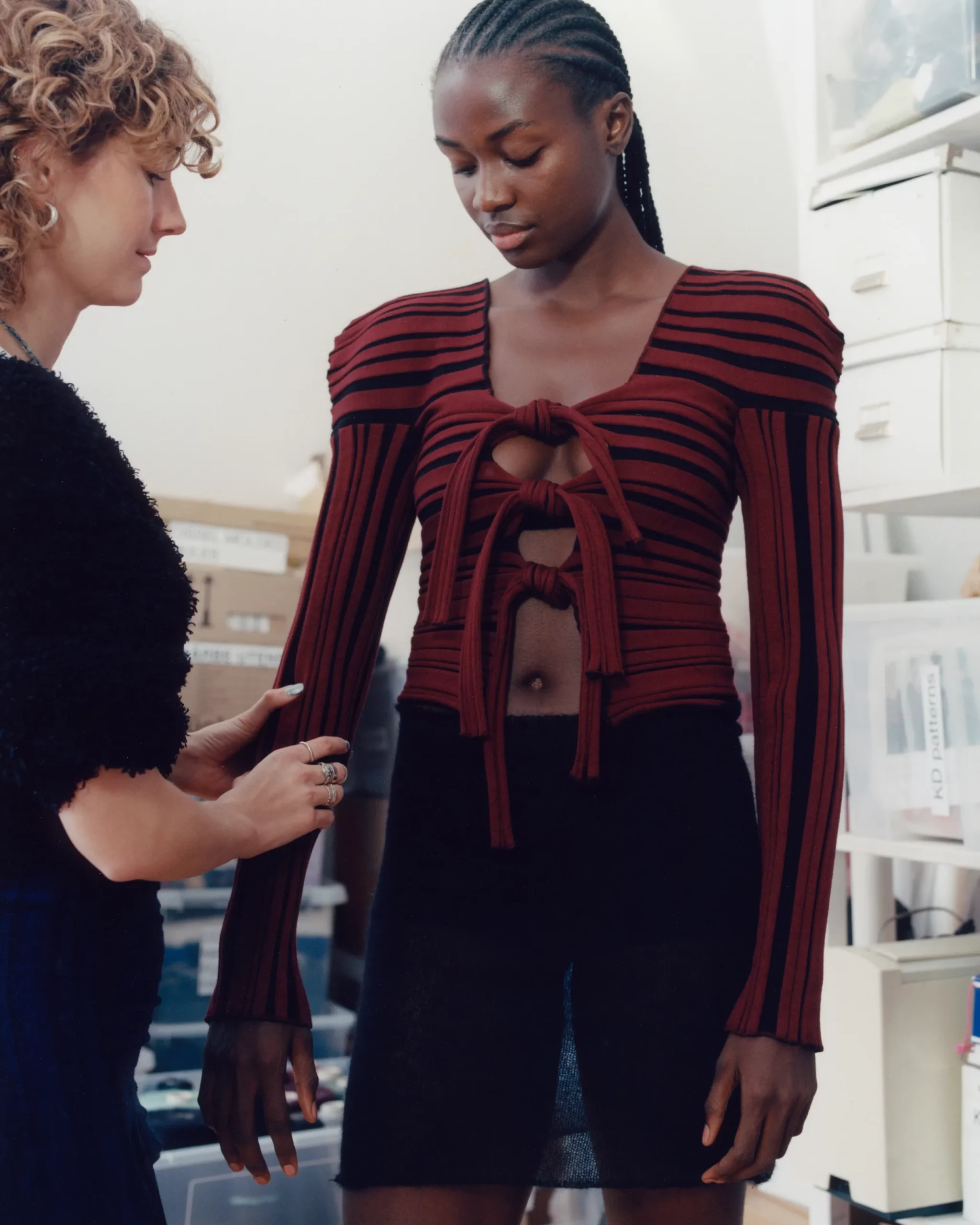 Female black model Ibukun Sammy getting fitted by Berlin based knitwear designer Katharina Dubbick in the designer's studio. Photographed by Charlotte Helwig.