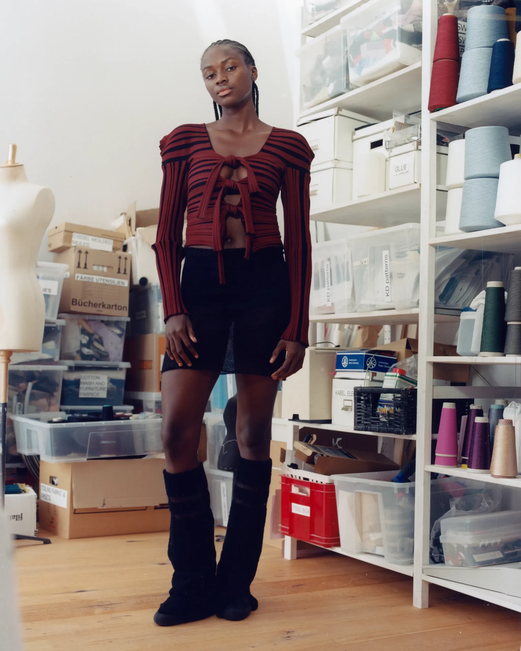 Female black model Ibukun Sammy wearing a design by Berlin based knitwear designer Katharina Dubbick in the designer's studio. Photographed by Charlotte Helwig.