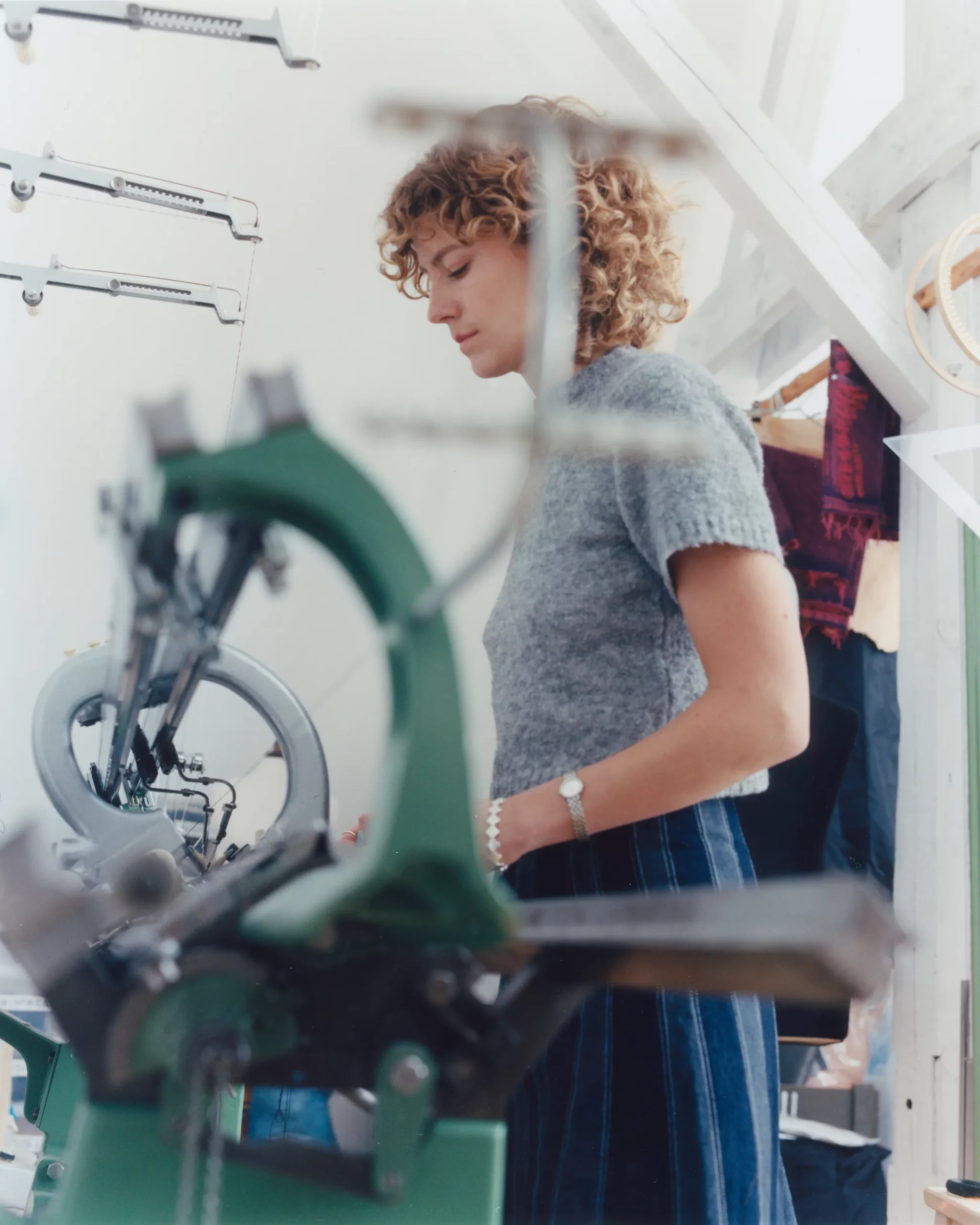 Berlin based Knitwear designer Katharina Dubbick working at a knitting machine in her studio. photographed by Charlotte Helwig.