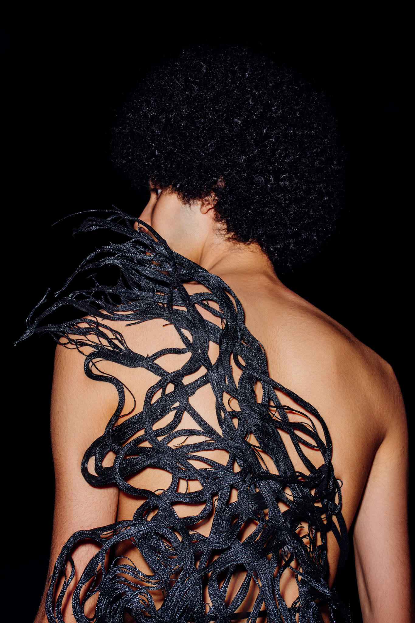 Topless model Yassin Walhezi, photographed from back, wearing a piece by Malteza Atelier.