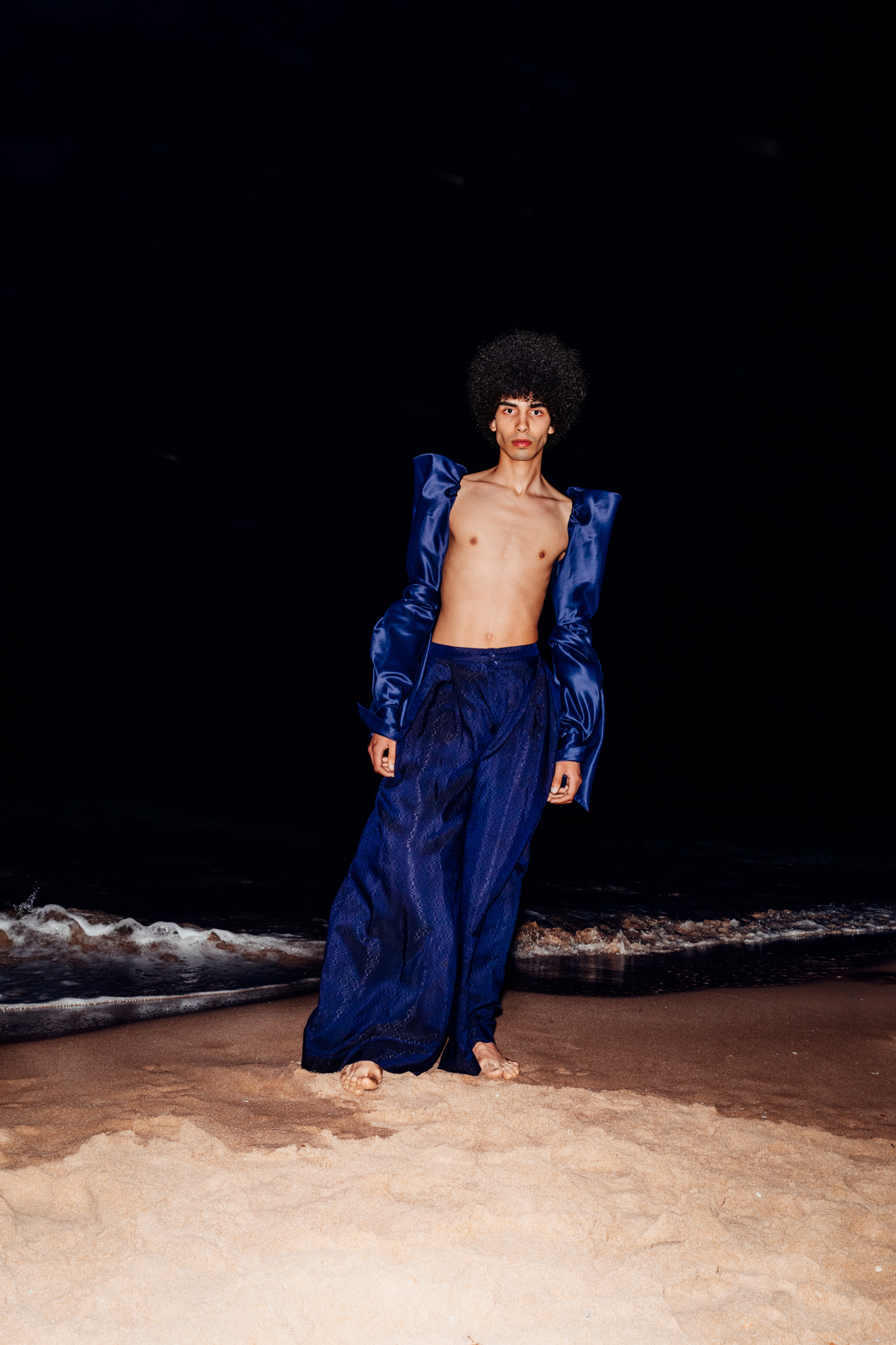 tunisian Model Yassin Walhezi standing at the beach in Tunis at night time. Wearing