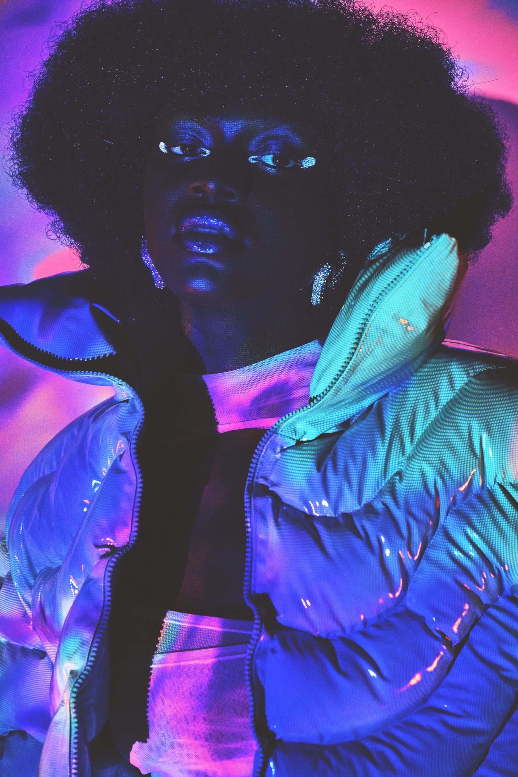 close up shot of black model in puffer jacket and dress shot with slow shutter and colorful light