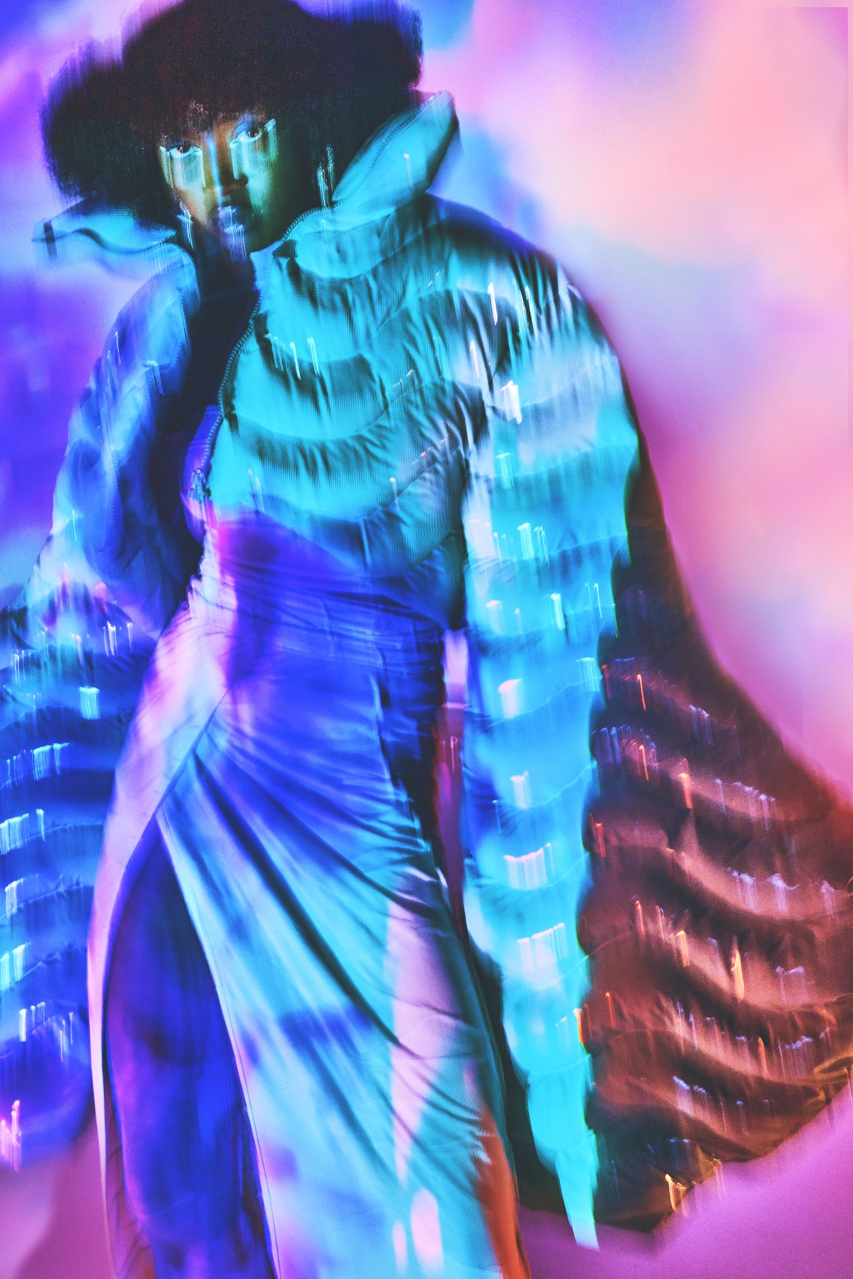 Three quarter shot of black model in puffer jacket and dress shot with very slow shutter and colorful